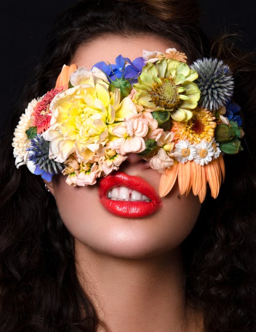 Model with floral mask over eyes and lip bite