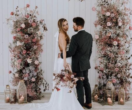 Bride and Groom with standing floral arches.