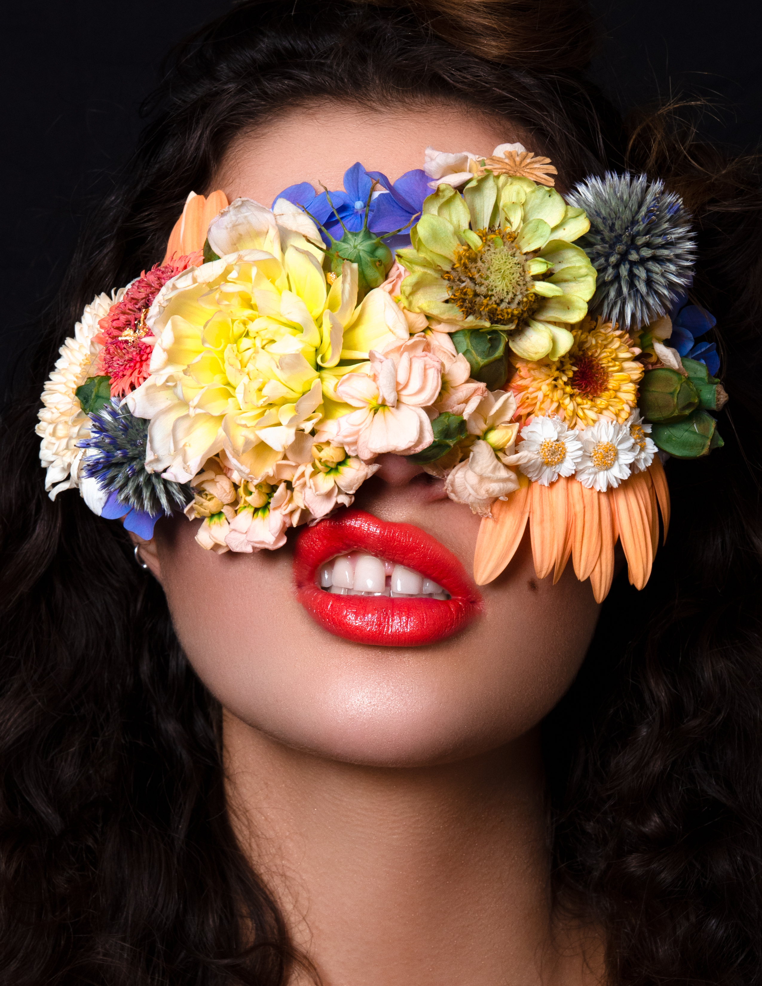model with floral mask over eyes and lip bite